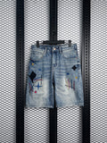 Acid-wash denim shorts with abstract embroidery and patches
