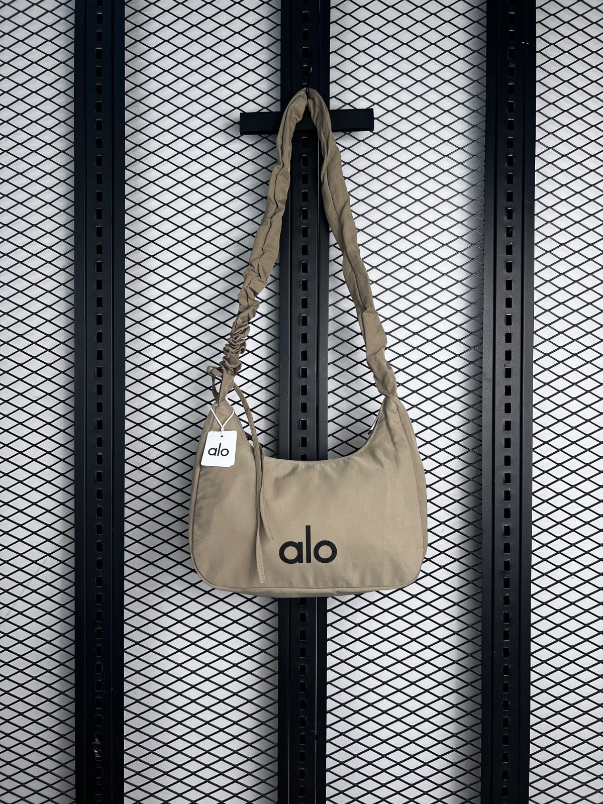 Cream nylon crescent shoulder bag with ruched strap